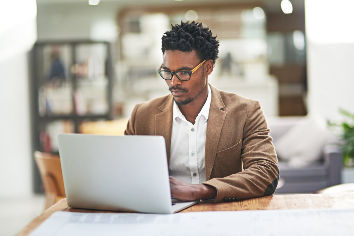 Black businessman focused on laptop at office desk